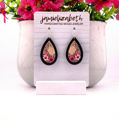 Pink awareness ribbon surrounded by flowers and greenery, teardrop earrings with Black wood frames by Jamielizabeth