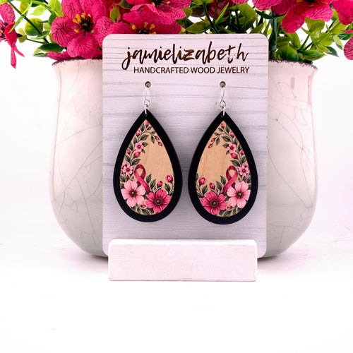 Pink awareness ribbon surrounded by flowers and greenery, teardrop earrings with Black wood frames by Jamielizabeth