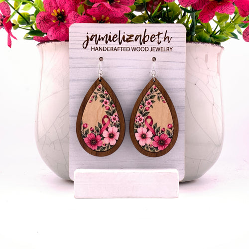 Pink awareness ribbon surrounded by flowers and greenery, teardrop earrings with Walnut wood frames by Jamielizabeth